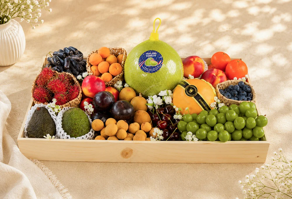 Moon Drop Grapes, Apricot, Pomelo, Yellow Nectarine, Mandarin Orange, Rambutan, Rockit Apple, China Plum, Longan, Canadian Cherries, Korean Pear, Blueberry, Avocado, Green Muscat Grapes in a Premium Wooden Tray.
