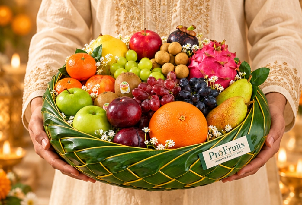 Premium leaf basket filled with exotic fruits including Black Grapes, Dragon Fruit, Egyptian Mangoes, Golden Kiwi, Mangosteen, Apples, Pears and a Diwali greeting card