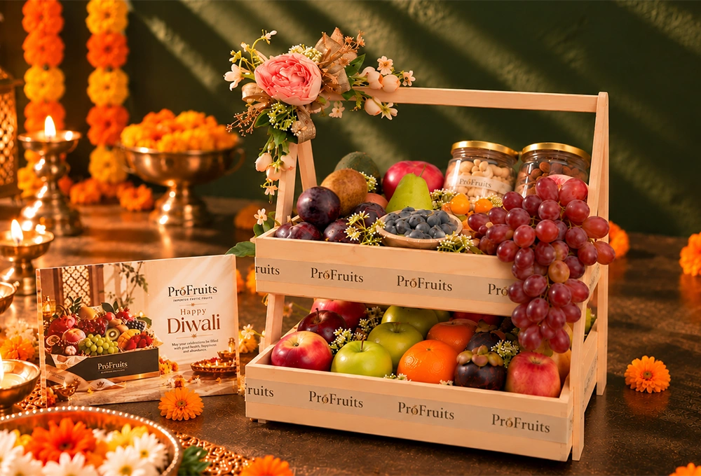 Green Kiwi, China Plum, Red Seedless Grapes, Vermont Pear, Fuji Apple, Avocado, Gooseberry, Green Apple, Rockit Apple, Murcott Orange, Mangosteen, Red Beauty Pear, Cashew Jar, and Almond Jar with a Double Stand Wooden Tray & Happy Diwali Greeting Card.