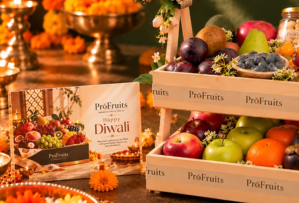 Green Kiwi, China Plum, Red Seedless Grapes, Vermont Pear, Fuji Apple, Avocado, Gooseberry, Green Apple, Rockit Apple, Murcott Orange, Mangosteen, Red Beauty Pear, Cashew Jar, and Almond Jar with a Double Stand Wooden Tray & Happy Diwali Greeting Card.