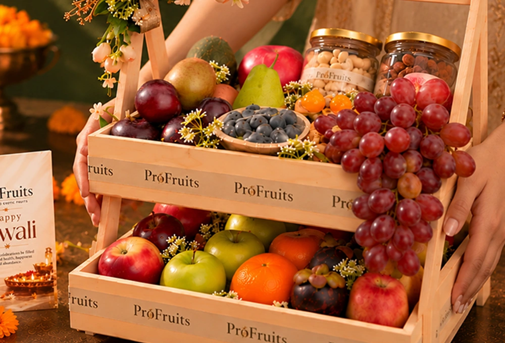 Green Kiwi, China Plum, Red Seedless Grapes, Vermont Pear, Fuji Apple, Avocado, Gooseberry, Green Apple, Rockit Apple, Murcott Orange, Mangosteen, Red Beauty Pear, Cashew Jar, and Almond Jar with a Double Stand Wooden Tray & Happy Diwali Greeting Card.
