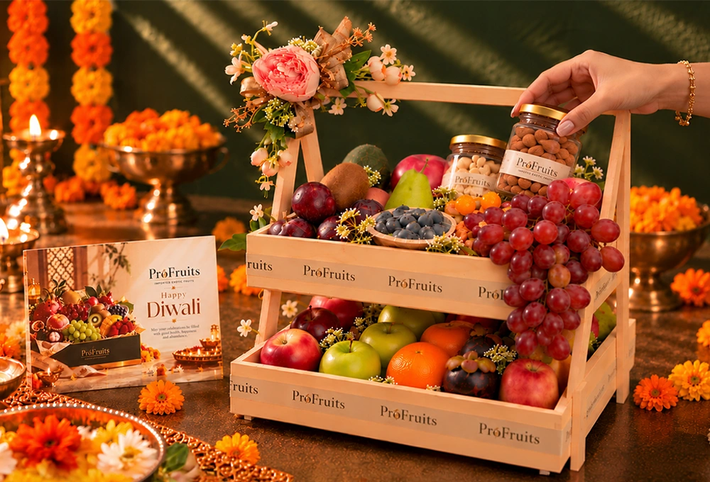 Green Kiwi, China Plum, Red Seedless Grapes, Vermont Pear, Fuji Apple, Avocado, Gooseberry, Green Apple, Rockit Apple, Murcott Orange, Mangosteen, Red Beauty Pear, Cashew Jar, and Almond Jar with a Double Stand Wooden Tray & Happy Diwali Greeting Card.