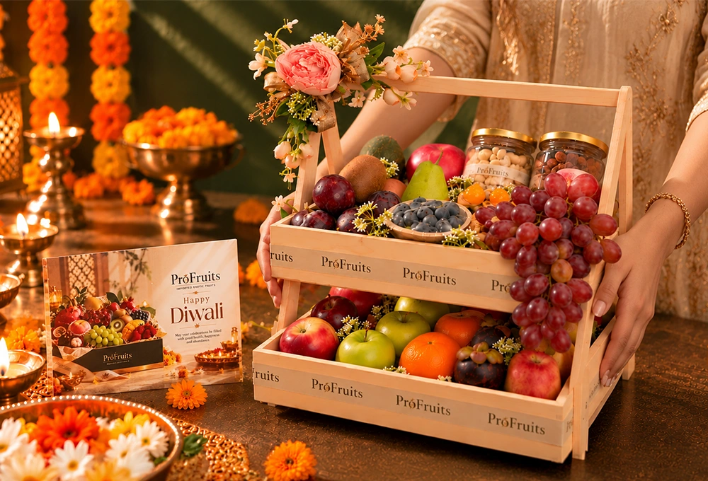 Green Kiwi, China Plum, Red Seedless Grapes, Vermont Pear, Fuji Apple, Avocado, Gooseberry, Green Apple, Rockit Apple, Murcott Orange, Mangosteen, Red Beauty Pear, Cashew Jar, and Almond Jar with a Double Stand Wooden Tray & Happy Diwali Greeting Card.