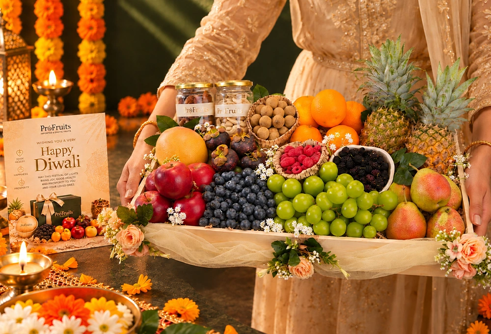 Rockit Apple, Grapefruit, Mangosteen, Longan, Blueberries, Red Seedless Grapes, Valencia Orange, Whole Honey Pineapple, Red Beauty Pear, Mulberries, Raspberries, Green Muscat Grapes, Cashew Jar, and Fig Jar with a Wooden Tray & Happy Diwali Greeting Card.