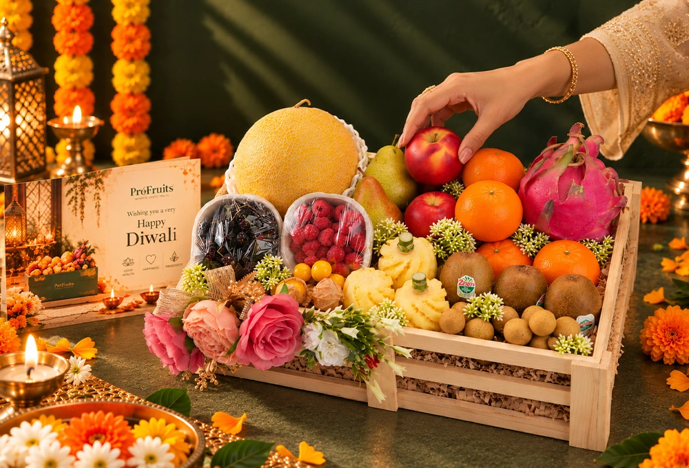 Golden Kiwi, Golden Emerald Muskmelon, Red Beauty Pear, Rockit Apple, Kutch Dragon Fruit, Murcott Orange, Longan, Honey Pineapple, Gooseberry, Mulberry, and Raspberry with a Wooden Tray & Happy Diwali Greeting Card.