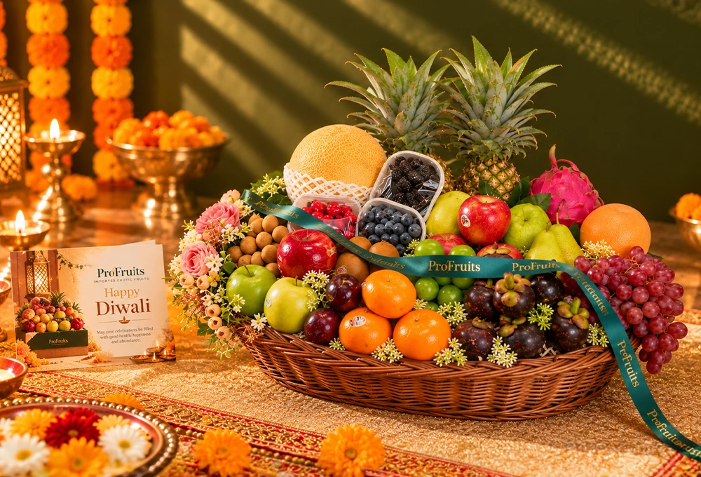 Green Apple, Murcott Orange, Golden Kiwi, Red Ice Guava, China Plum, Green Muscat Grapes, Mangosteen, Green Vermont Pear, Red Apple, Grapefruit, Pink Guava, Red Seedless Grapes, Kutch Dragon Fruit, Blueberries, Mulberries, Raspberries, Longan, Whole Pineapple, Golden Emerald Muskmelon, and Avocado with a Basket & Diwali Greeting Card.
