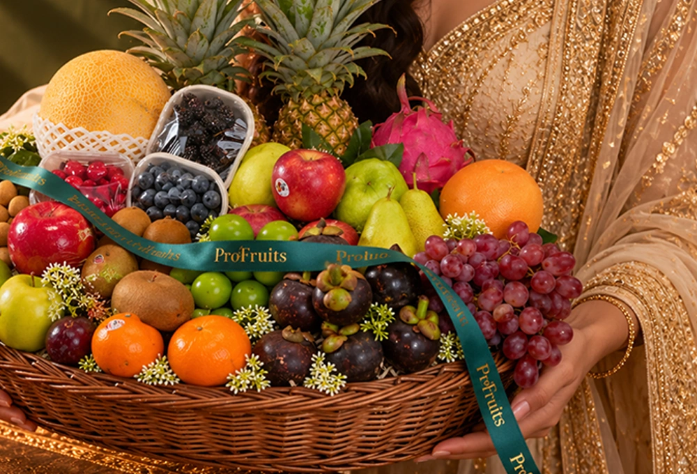 Green Apple, Murcott Orange, Golden Kiwi, Red Ice Guava, China Plum, Green Muscat Grapes, Mangosteen, Green Vermont Pear, Red Apple, Grapefruit, Pink Guava, Red Seedless Grapes, Kutch Dragon Fruit, Blueberries, Mulberries, Raspberries, Longan, Whole Pineapple, Golden Emerald Muskmelon, and Avocado with a Basket & Diwali Greeting Card.